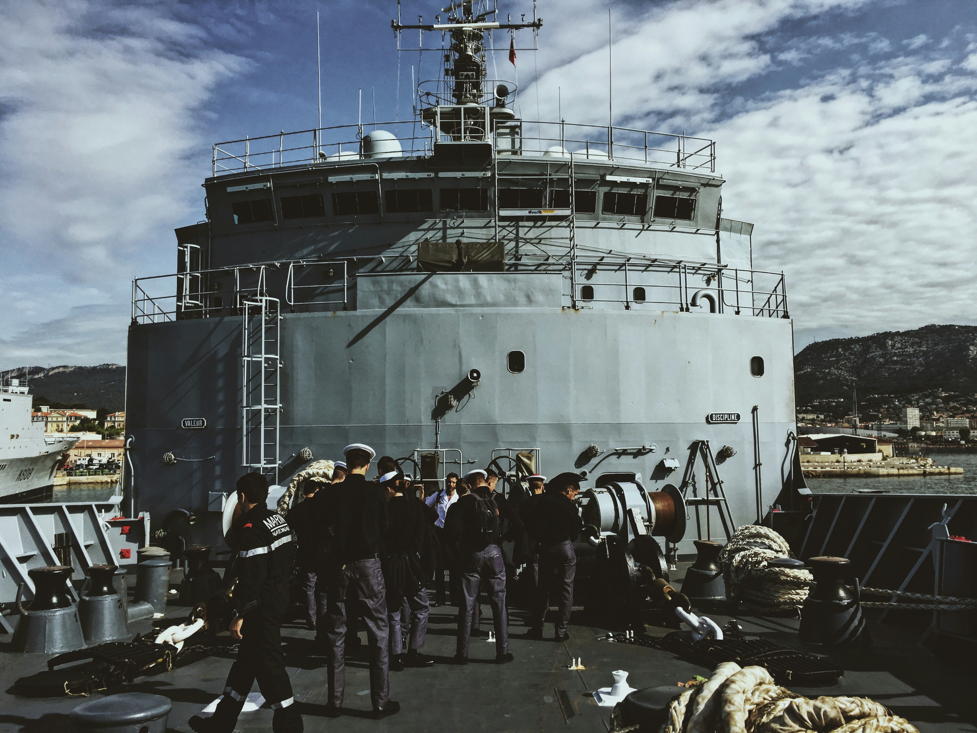 people standing outside round metal tank